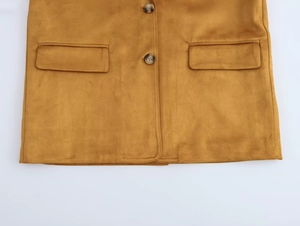 Détail d'un blazer en suédine avec poches à rabat et boutons à motif ambré