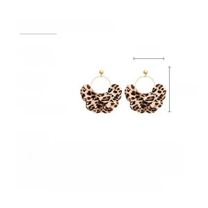 Detailed view showing multi-layered leopard print fabric earrings with gold-tone hooks
