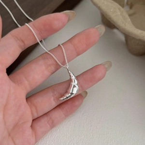 Minimalist 925 sterling silver croissant pendant necklace shown in hand with high polish