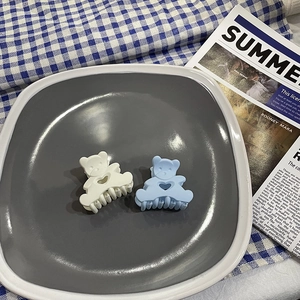 Detail of matte macaron bear hair claws in white and blue on a decorative tray