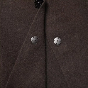 Detailed macro view of dark brown wool coat with metallic buttons and sequin trim collar