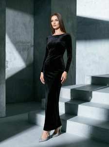 Elegante abito da sera lungo in velluto nero con schiena scoperta su scale moderne