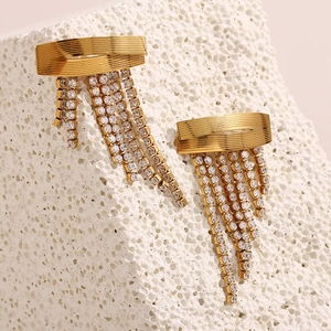 Vue détaillée des boucles d'oreilles pompons dorées 18K avec cristaux sur pierre blanche