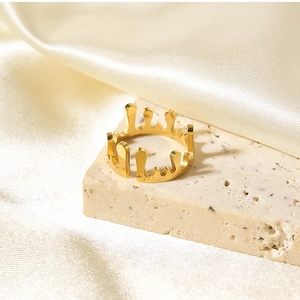 Macro detail of golden crown water drop ring on silk background with fluid lava design