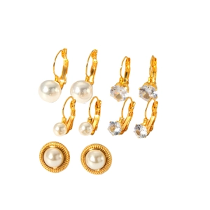 Ensemble de boucles d'oreilles vintage en or avec perles et cristaux sur fond blanc