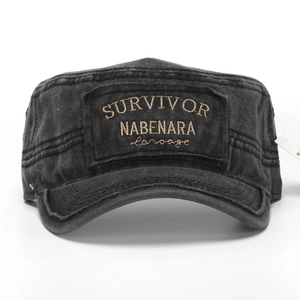 Detail of washed cotton cadet cap featuring embroidered survivor text and reinforced brim