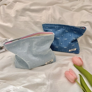 Blue denim cosmetic bags with white bow embroidery and pink zipper in two shades