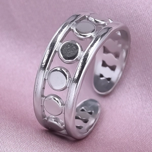 Detail of silver moon phase adjustable ring on soft pink silk background