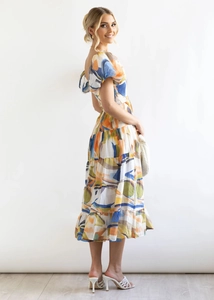 Detail of summer puff sleeve floral dress with colorful abstract print and tiered skirt layers