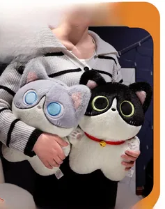 Close-up of a soft plush cat toy with collar and bell, shown being held by a model
