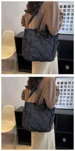 Detail of black quilted tote bag showing diamond stitch pattern and side pockets