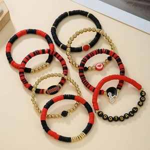 Close-up of football-themed beaded bracelets with red, black, and gold charms