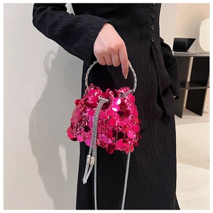 Close-up of vibrant magenta sequin bucket bag with silver metal handle and chain strap