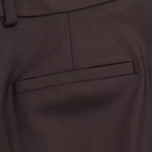 Détail du tissu tissé de qualité et de la poche passepoilée sur le pantalon de costume