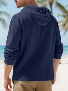 Detail of navy blue cotton linen hooded shirt with breathable texture on tropical beach