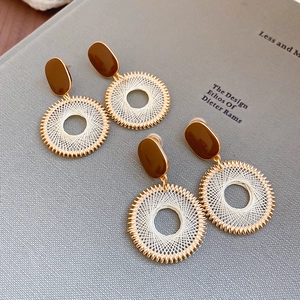 Detail of bohemian geometric mesh earrings on a minimalist designer book cover