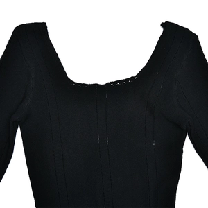 Detail shot of black knitted fabric texture with square neckline and ribbed pattern