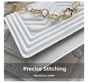 Close-up of V-quilted stitching and gold flower chain on the white crossbody bag