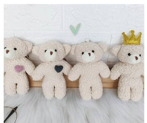 Detail view of four mini teddy bear plush keychains with various heart and crown designs