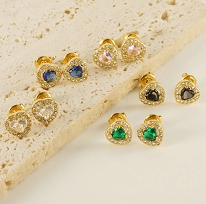 Vue macro de boucles d'oreilles cœur en or serties de zircons colorés sur socle pierre