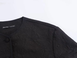 Close-up of black floral embroidery texture and collar detail on a casual jacket