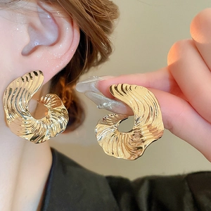 Exaggerated golden metallic striped geometric earrings with an irregular spiral design