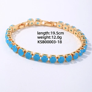 Close-up of golden chain bracelet with sky blue round cubic zirconia stones and metal clasp
