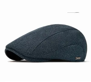 Detail view of navy blue newsboy cap showing fine knit texture and small metal logo