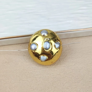 Detail of a gold-plated round bead featuring inlaid oval blue pearls for DIY jewelry making