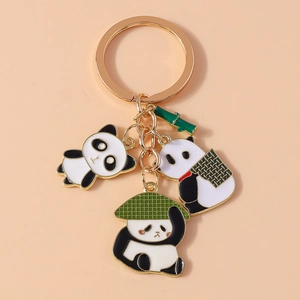 Detail of three enamel panda pendants and a gold bamboo charm on a stylish keychain