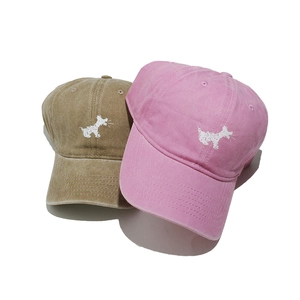 Detail of khaki and pink washed cotton baseball caps with cute dog embroidery details