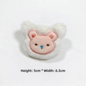 Detail of white plush bear head DIY accessory with pink embroidery measuring 5cm x 6.5cm