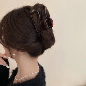 Elegant large amber leopard print hair claw clip shown from back on model hairstyle