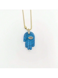 Detalle de un collar con colgante de mano de Hamsa turquesa y un ojo de la suerte