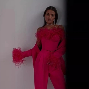 Two-piece fuchsia suit with ostrich feather trim featuring tube top and wide-leg trousers