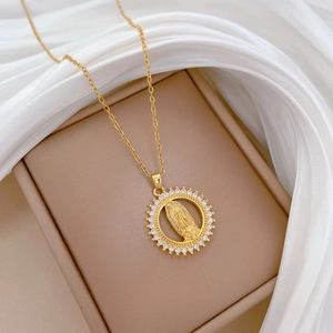 Detailed macro view of a gold plated Virgin Mary pendant necklace with cubic zirconia