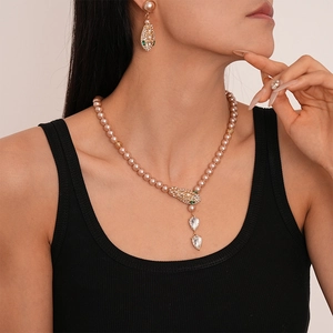 Detailed view of snake head pendant with rhinestones and water drop pearls set