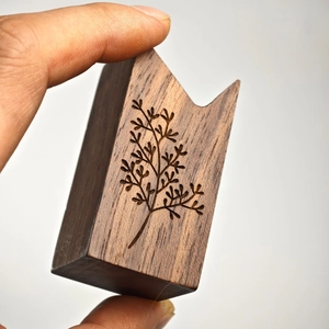 Conical black walnut and brass ring holder with intricate engraved branch pattern detail