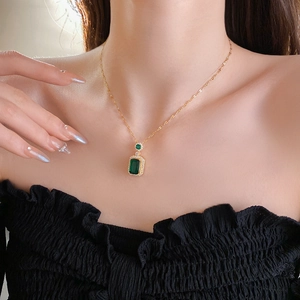 Detail of a vintage emerald pendant necklace with diamonds worn by a model
