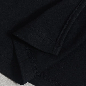 Detailed macro view of black knit dress hem with professional double-stitched sewing