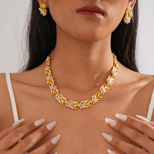 Detailed view of vintage gold leaf jewelry set with zircons and pearls on a model