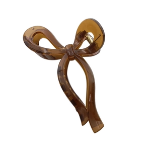 Brown translucent bow-shaped hair claw clip with golden spring on white background