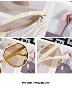 Detail view of cream oversized sunglasses with sturdy metal hinges and amber lenses