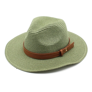 Détail du chapeau de paille vert sauge avec ruban en cuir et rivets dorés