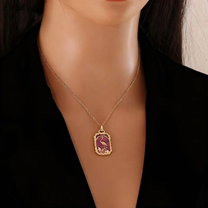 Golden necklace with purple enamel flamingo pendant shown on a female model