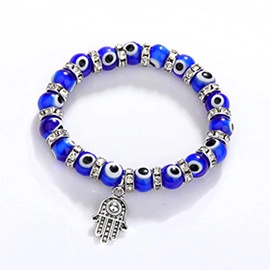 Detailed view of woven evil eye bracelet with Hamsa palm charm and sparkling rhinestones