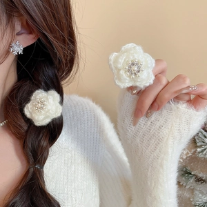 Détail d'une pince à cheveux fleurie en tricot avec perles sur un mannequin féminin