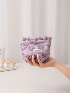 Cute purple plush heart-pattern cosmetic bag with H&R BAG label held in hand