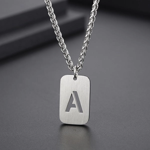 Vue macro de la chaîne épi argentée et du pendentif rectangulaire avec la lettre A