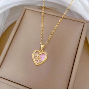 Golden heart necklace with pink enamel and sparkling flower pendant on jewelry box